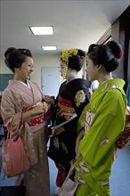 JAPAN, Honshu, Kyoto, "Gion area.  Three Maiko or apprentice geisha wearing kimonos, talking and