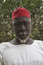 GAMBIA, Western Gambia, Tanji, Tanji Village.  Head and shoulders portrait of Muslim man with white