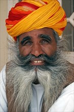 INDIA, Rajasthan, Jodhpur, "Meherangarh Fort.  Head and shoulders portrait of a smiling Indian man