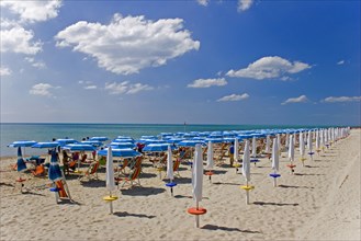 ITALY, Basilicata, Metaponto, Lines of coloured sun umbrellas and striped deck-chairs along quiet