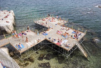 ITALY, Sicily, Syracuse, "Looking down on platform structure raised above rocky sea with steps to