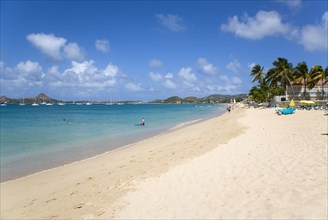WEST INDIES, St Lucia, Gros Islet, Reduit Beach in Rodney Bay with tourists in the water and on the