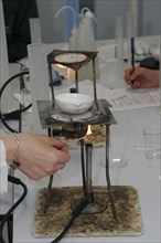 CHILDREN, Education, Secondary, Teacher lighting a bunsen burner prior to it being used for a food