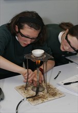 CHILDREN, Education, Secondary, Food technology science class pupil using bunsen burner