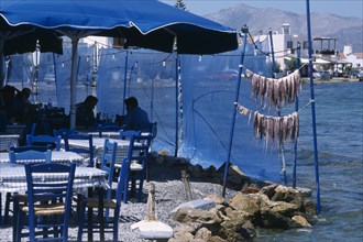 GREECE, Peloponnese, Elafonisos , Restaurant outside seating with blue table and chairs next to