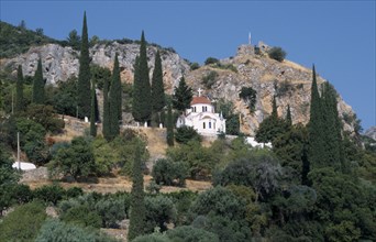 GREECE, Peloponnese, Molai , White church with red tilled dome on tree covered hillside