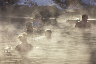 20091048 People outdoor hot pool spa resort  with steam rising cold air. Property Released American Holidaymakers North America Tourism Tourist United States America  WeatherWaterDominant BrownPeop...