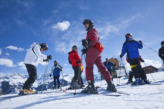 20091052 Group skiers about descend mountain. American Holidaymakers North America Tourism Tourist United States America  Dominant YellowDominant RedDominant BluePeople - GroupLeisure ActivitiesS...
