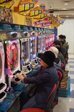 JAPAN, Honshu, Tokyo, "Shinjuku, Kabuki-cho.  Japanese men and women betting on electronic gambling