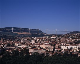 FRANCE, Midi-Pyrenees, Aveyron, Millau.  Cityscape with Millau bridge beyond which carries the A75