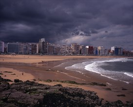 SPAIN, Asturias, Gijon, "High rise city buildings overlooking beach with people in water, on beach