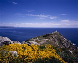 SPAIN, Galicia, Cabo Fisterra, View over rocky peninsula towards Atlantic Ocean with yellow