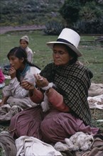 PERU, , Woman wearing a white Panama hat hand spinning wool into yarn.