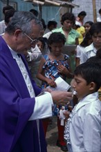 ECUADOR, Guayas Province, Guayaquil , Roman Catholic Bishop giving Communion in Barrio Indio Guayas