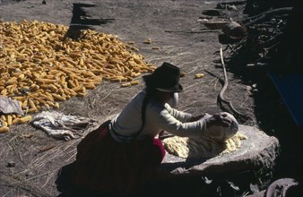 BOLIVIA, Yayani,  Woman grinding maize. Near Cochabamba.