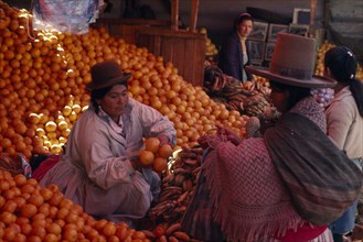 BOLIVIA, Potosi, Woman selling oranges from her market stall