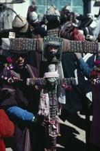 BOLIVIA, Macha , Tingku Festival Day. Man holding a large decorated cross with the face of Jesus