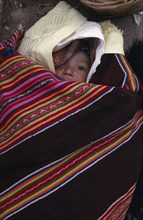 BOLIVIA, Potosi, Aymara baby wrapped in local poncho