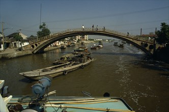 CHINA, Jiangsu Province, Transport, Barges travelling under bridge on the Grand Canal between