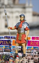 ITALY, Lazio, Rome, Souvenir stall in the Forum with statue of a uniformed Roman soldier among map