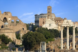 ITALY, Lazio, Rome, View of The Forum with the Colosseum rising behind the bell tower of the church