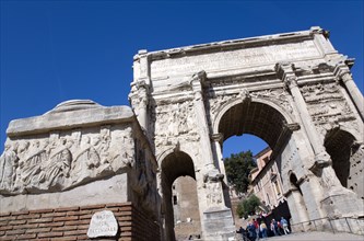 ITALY, Lazio, Rome, Tourists walking through the triumphal Arch of Septimius Severus in the Forum