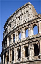 ITALY, Lazio, Rome, Detail of The Colosseum amphitheatre exterior with tourists walking past built
