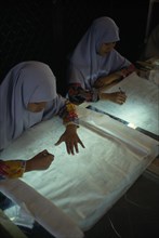 MALAYSIA, Crafts, Young women tracing floral patterns first on to paper then transferring them to