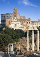ITALY, Lazio, Rome, View of the Forum with the Colosseum rising behind the bell tower of the church