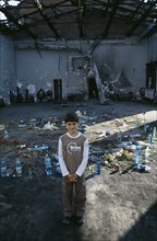 RUSSIA, South, Beslan, "Child standing in front of tributes left in school destroyed during 2004