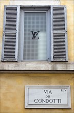 ITALY, Lazio, Rome, Road sign for the Via dei Condotti on the wall of the Louis Vuiton shop in the