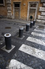 ITALY, Lazio, Rome, Automatic rising bollards and a pedestrian crossing in a side street with red