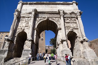ITALY, Lazio, Rome, Tourists walking through the triumphal Arch of Septimius Severus from the Forum