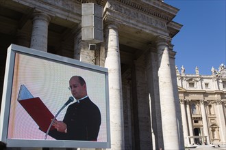 ITALY, Lazio, Rome, Vatican City A cardinal reading from a red book seen on a large video TV