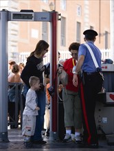 ITALY, Lazio, Rome, Vatican City Women with young boy at x-ray security mchine check manned by a