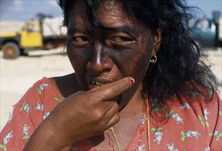 COLOMBIA, La Guajira, Manaure, Head and shoulders portrait of a woman cake seller eating a piece of