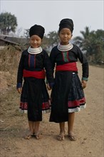 LAOS, Tribal People, Meo Tribe, Full length standing portrait of two Meo girls holding hands and