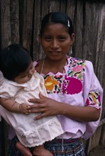 GUATEMALA, Alta Verapaz, Sacaak , Q’eqchi Indian mother wearing a traditional embroidered blouse