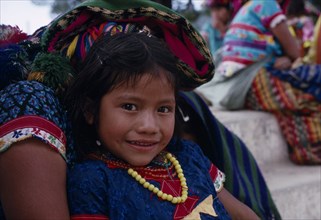 GUATEMALA, El Quiche, San Andres de Sacabaja, Portrait of a young Quiche Indian girl sitting on her