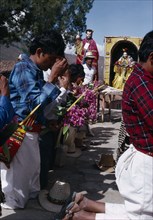 GUATEMALA, El Quiche, San Andres de Sajcabaja, Quiche Indian men knelling in prayer to the saints