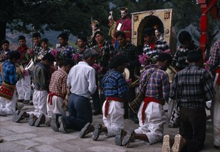 GUATEMALA, El Quiche, San Andres de Sajcabaja, Quiche Indians knelling in prayer to saints outside