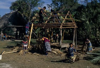 USA, Florida, Everglades, Independent Seminole Native Americans thatching a Chickee hut using palm