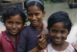 BANGLADESH, Khulna, Char Kukuri Mukuri, Head and shoulders group portrait of three smiling young