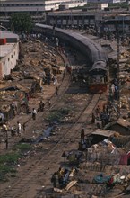 BANGLADESH, Dhaka, Train travelling through Tejgoan slum with ramshackle dwellings beside tracks