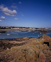 UNITED KINGDOM, Channel Islands, Jersey, Grouville. View across rocky foreshore with small boats on