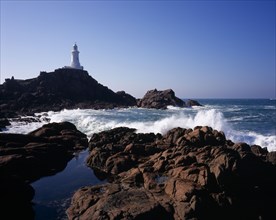 UNITED KINGDOM, Channel Islands, Jersey, St Brelade. Corbiere Lighthouse with waves crashing