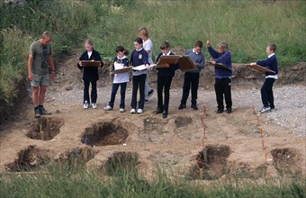 ENGLAND, Yorkshire, Whitby Abbey, Students and teacher on school field trip at archaeological dig