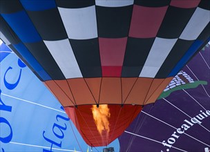 SWITZERLAND, Canton de Vaud, Chateau d'Oex, Close up of flame entering Hot Air Balloon to heat the