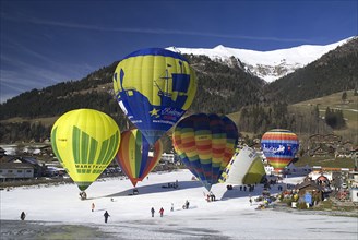 SWITZERLAND, Canton de Vaud, Chateau d'Oex, Hot Air Balloon taking off with others in preparation.