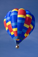SWITZERLAND, Canton de Vaud, Chateau d'Oex, Single colourful Hot Air Balloon as it ascends after